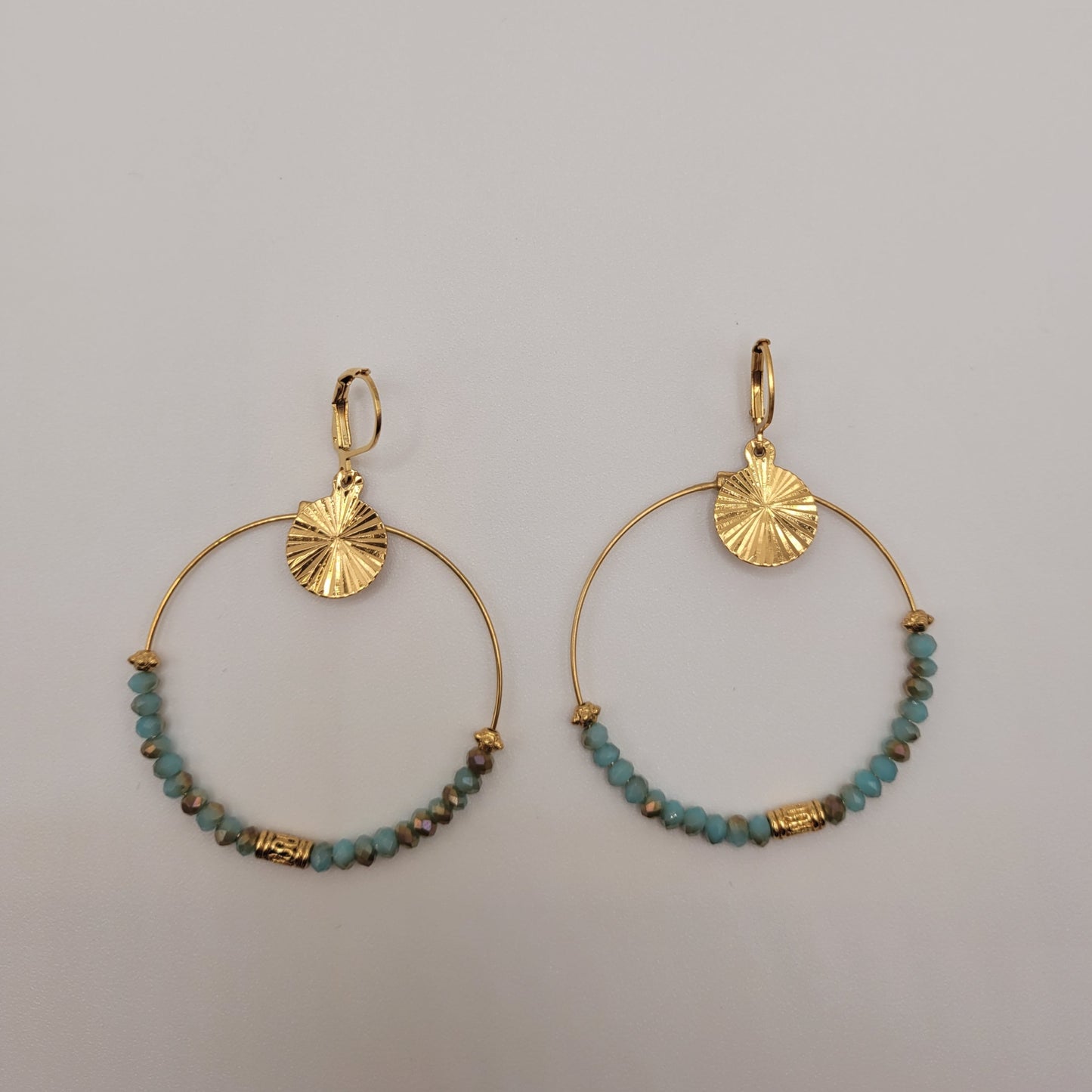 Nathalie, Boucles d'oreilles créoles dorées à l'or fin et perles facettées bleues.