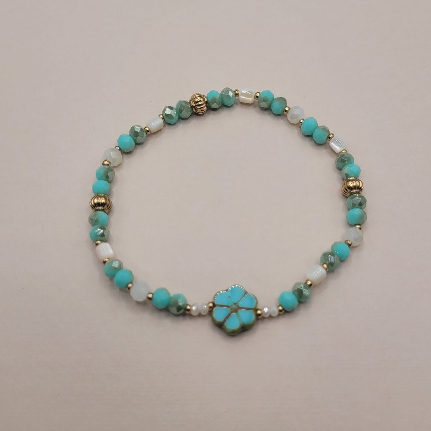 Lyana, Bracelet en perles en verre, perles en coquillage et perles dorées à l'or fin.