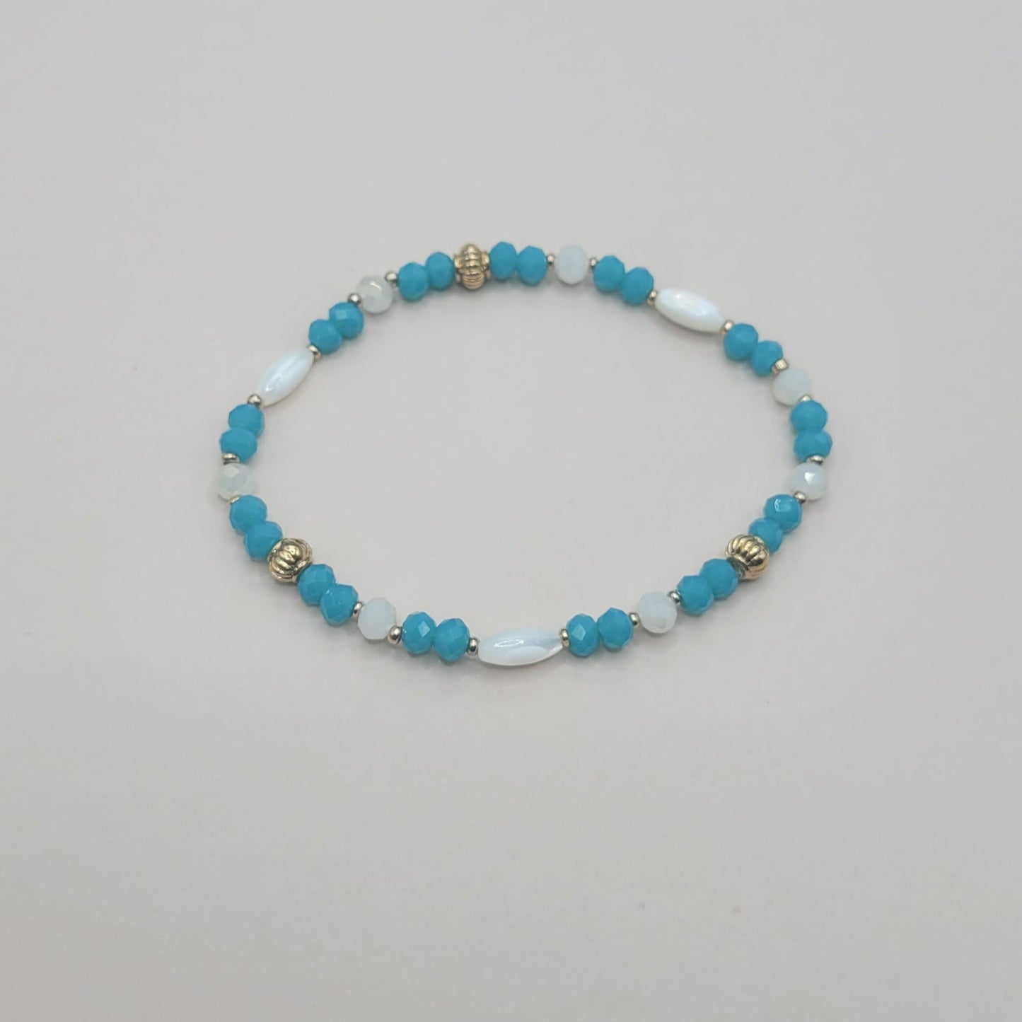 Lya, Bracelet en perles en verre, perles en coquillage et perles dorées à l'or fin.