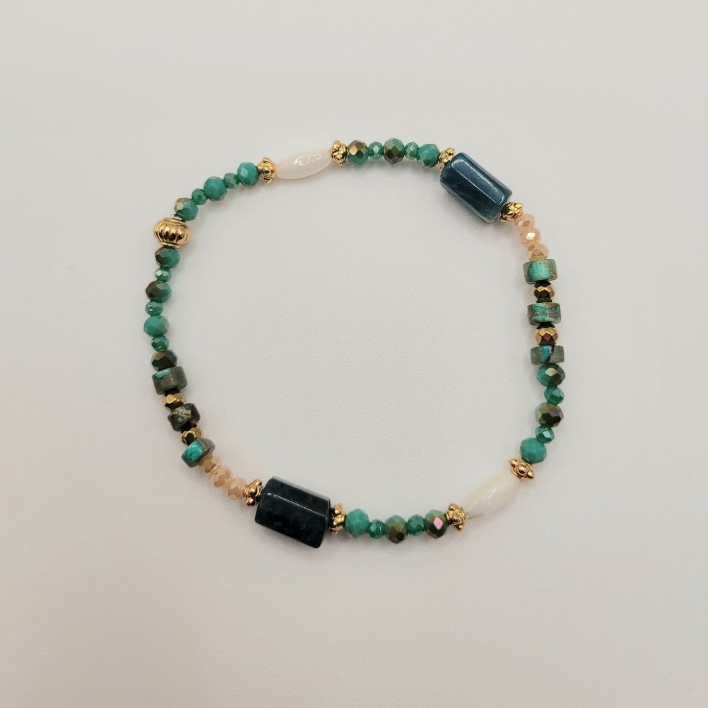 Flawia, Bracelet en perles en verre, nacre, apatite, régalite et perles dorées à l'or fin.