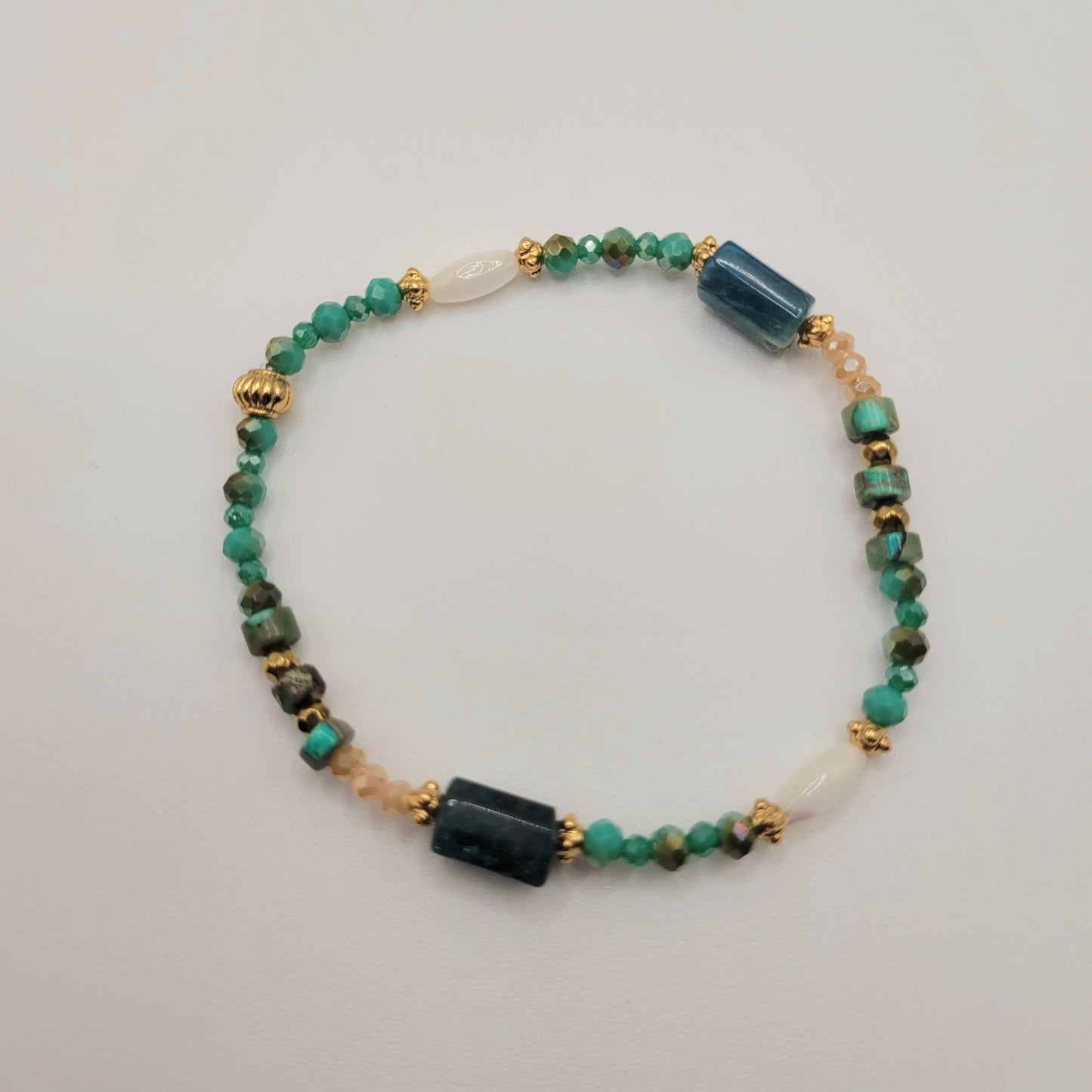 Flawia, Bracelet en perles en verre, nacre, apatite, régalite et perles dorées à l'or fin.