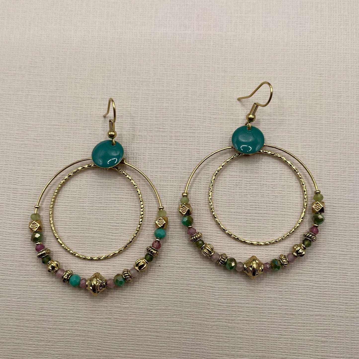 Sansa, Boucles d'oreilles créoles dorées à l'or fin, perles en verre facettées vertes et tourmaline.